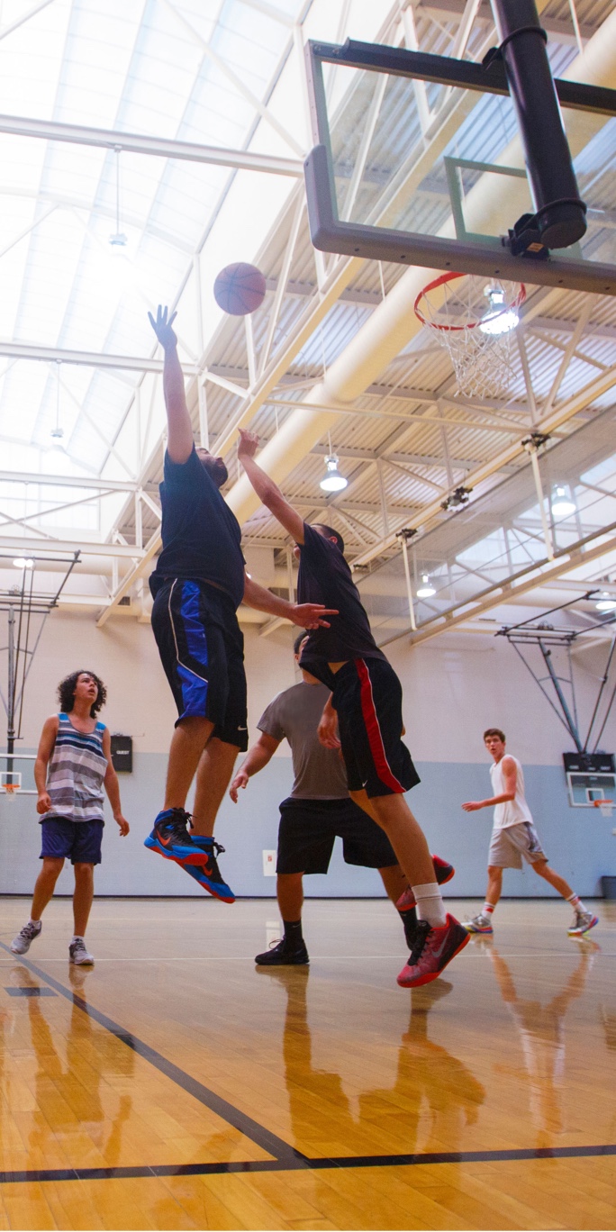 Students playing basketball in the gym.